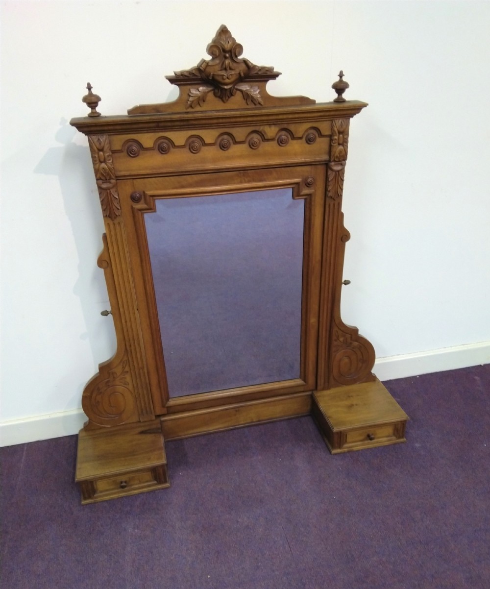 A carved French walnut dressing table mirror featuring an ornate carved pediment, fluted side columns, rectangular mirror glass, and two small trinket drawers at the base. View II