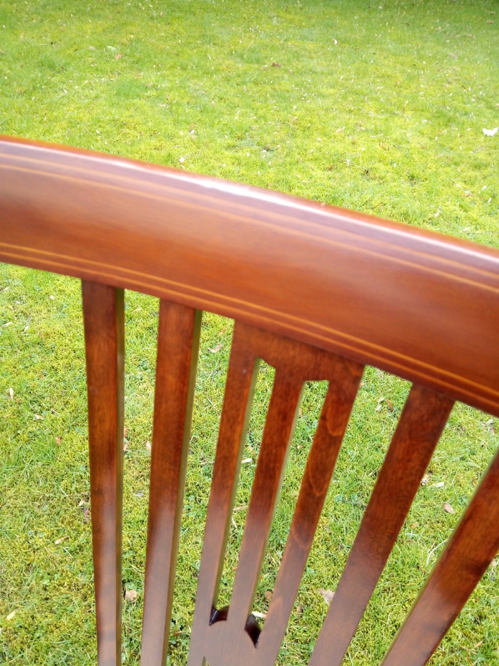 An Edwardian mahogany side chair featuring vertical back splats with fine string inlay and a cream upholstered drop-in seat. View VI