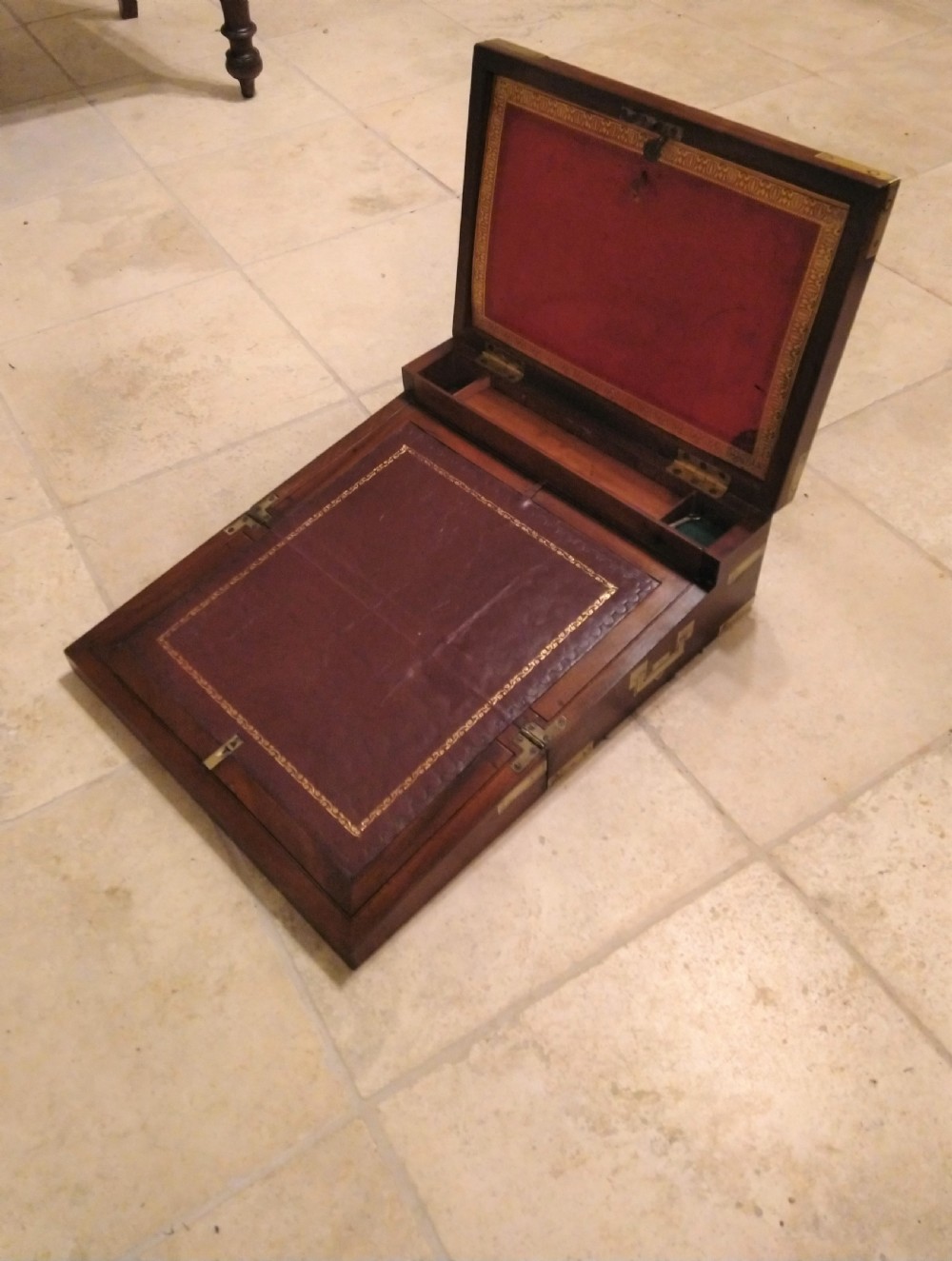 A rectangular dark mahogany wood writing slope featuring polished brass corner mounts, an escutcheon, and a brass central cartouche. View VI
