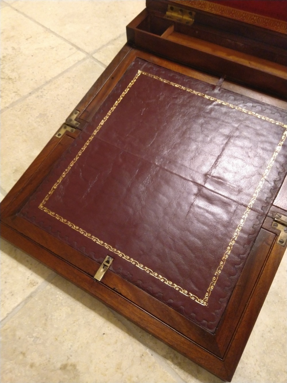A rectangular dark mahogany wood writing slope featuring polished brass corner mounts, an escutcheon, and a brass central cartouche. View VII