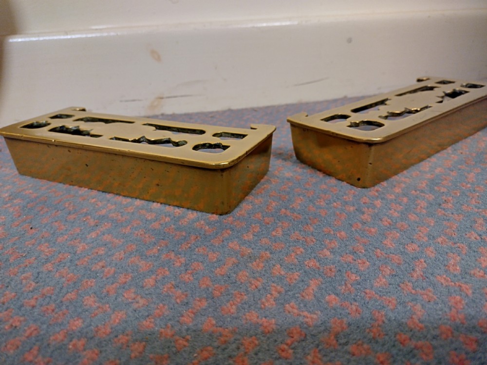 A pair of 19th-century rectangular cast brass fireplace trivets with pierced fretwork decoration and integrated fender mounting hooks. View II