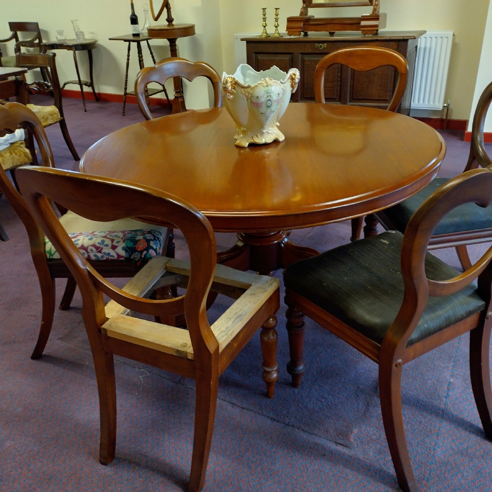 A 19th-century circular mahogany tilt-top pedestal table shown positioned vertically on splayed legs with castors. View VI