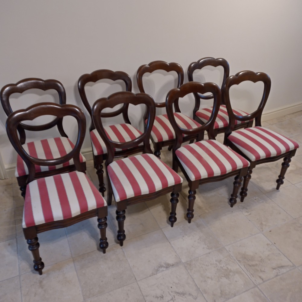 A set of eight 19th-century mahogany balloon back dining chairs with red and white striped upholstered seats and turned front legs. View II