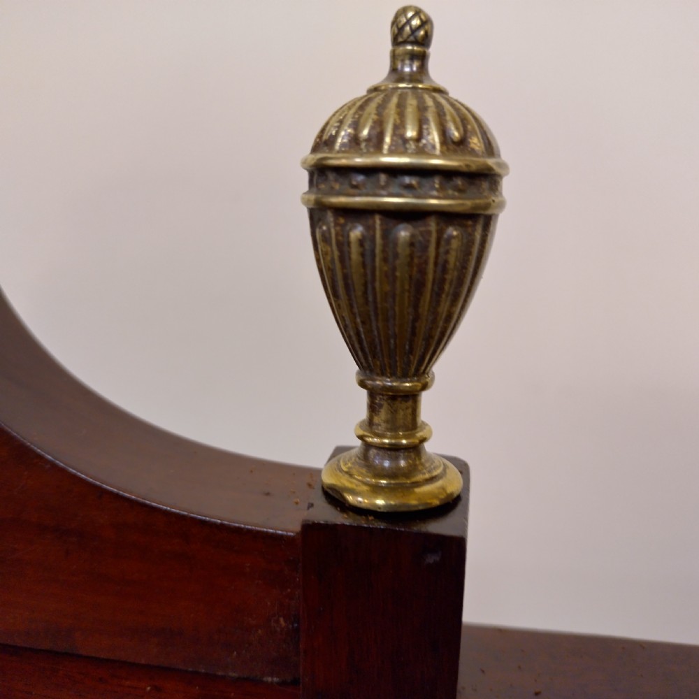 An Edwardian inlaid mahogany pedestal desk featuring twin pedestals with multiple drawers, brass oval drop handles, a dark leather writing insert, and a low gallery back with urn finials. View V