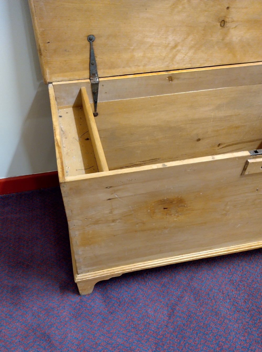 A nineteenth-century rectangular pine bedding chest with a hinged lid, brass keyhole escutcheon, and shaped bracket feet. View V