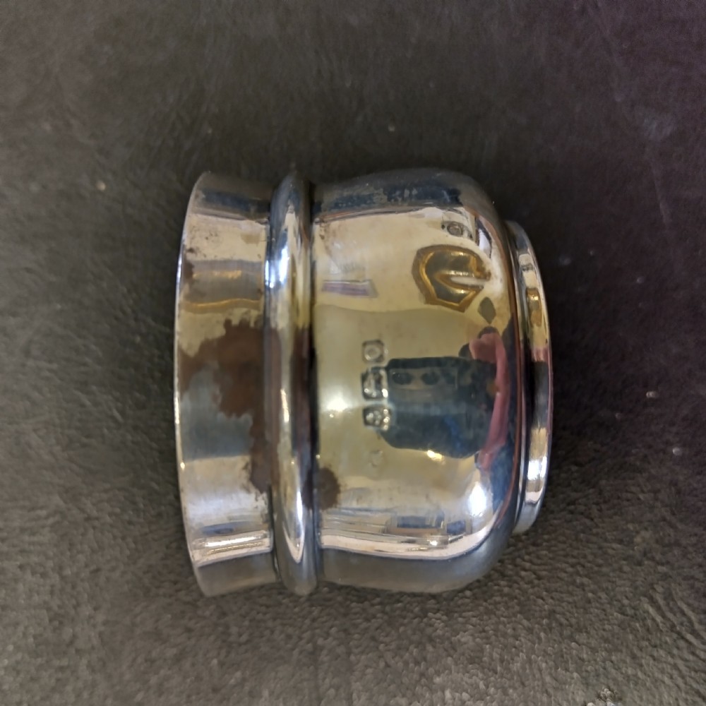 A circular sterling silver salt cellar with a cobalt blue glass liner insert and a silver salt spoon. View VI