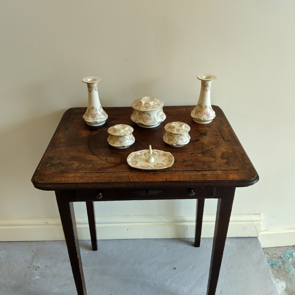 A six-piece cream porcelain dressing table set decorated with pink floral transfer patterns, gilt rims, two candlesticks, three lidded pots, and a ring tray. View II