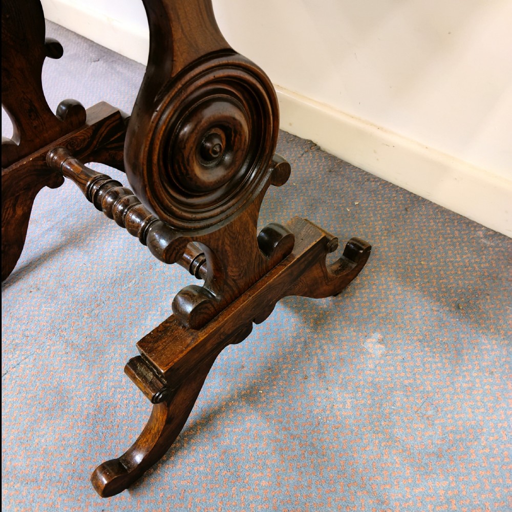 A 19th-century dark rosewood drop-leaf occasional table featuring a single drawer with wooden knobs, resting on curved trestle legs connected by a turned stretcher. View IV