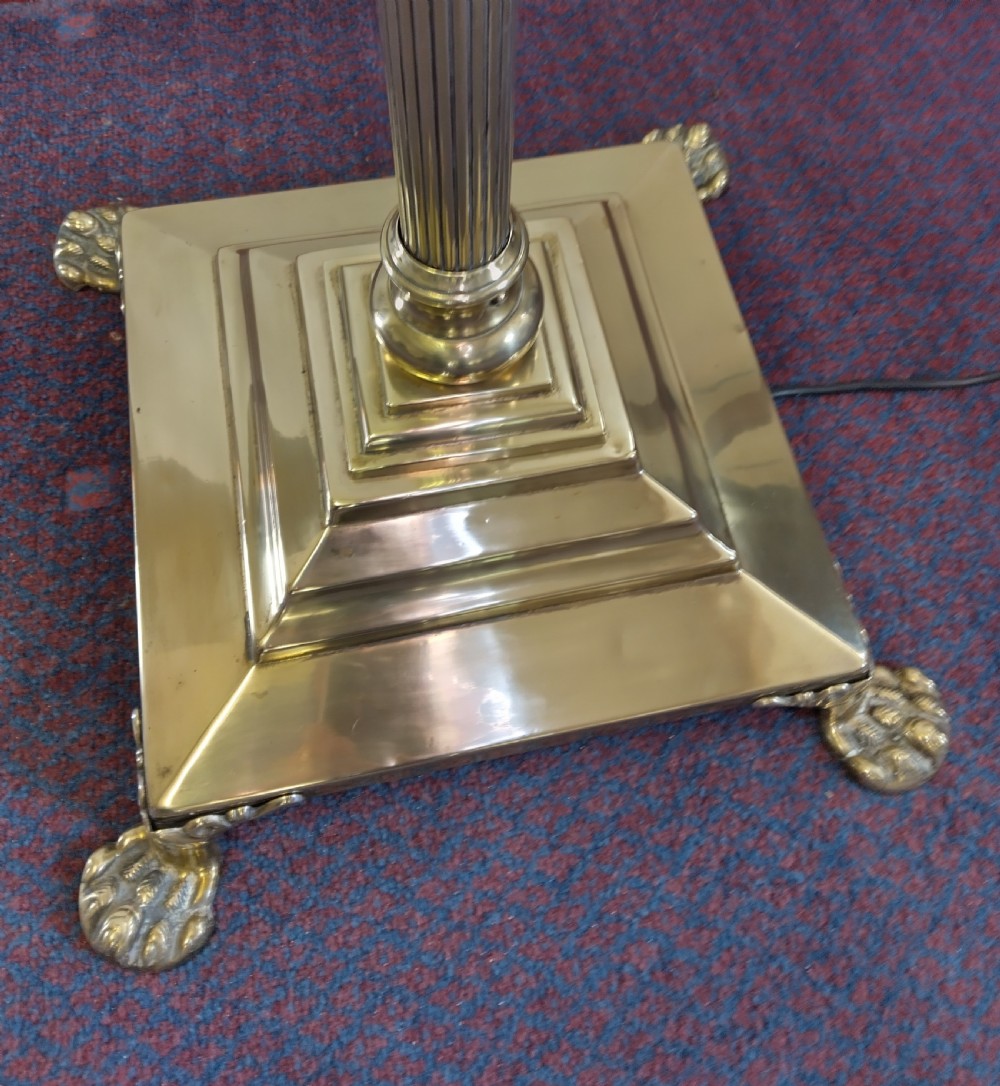 A solid brass Neoclassical standard lamp featuring a fluted column shaft, stepped square base on paw feet, and a tall cream fabric shade. View V