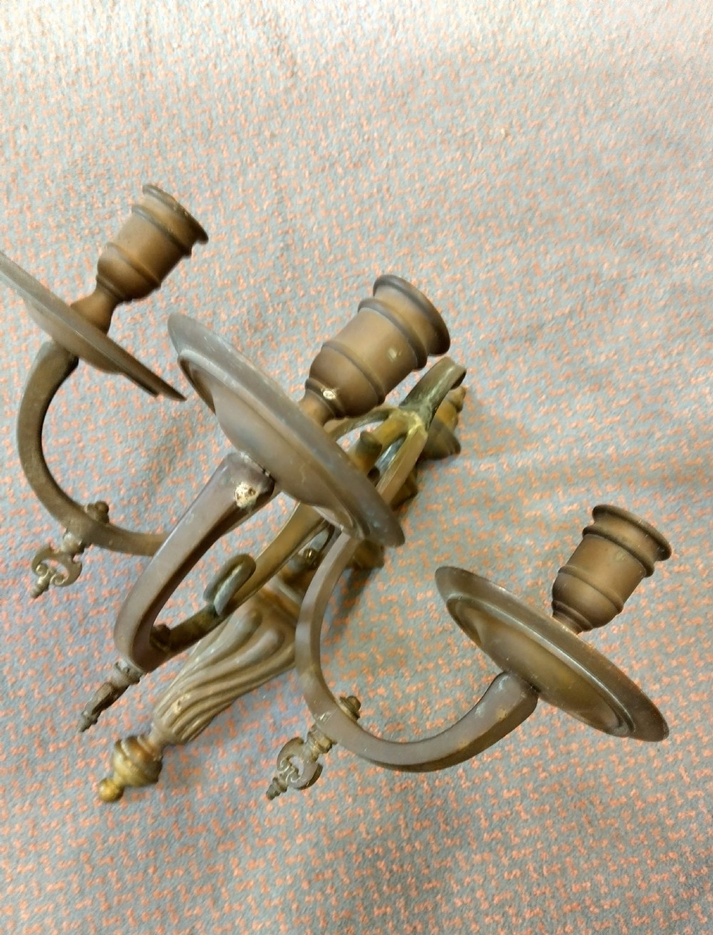 A pair of patinated three-arm solid brass wall sconces featuring fluted urn-shaped backplates and curved candle branches. View III