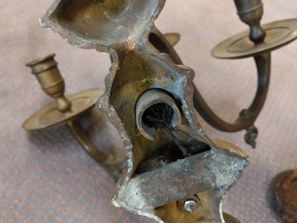 A pair of patinated three-arm solid brass wall sconces featuring fluted urn-shaped backplates and curved candle branches. View VI