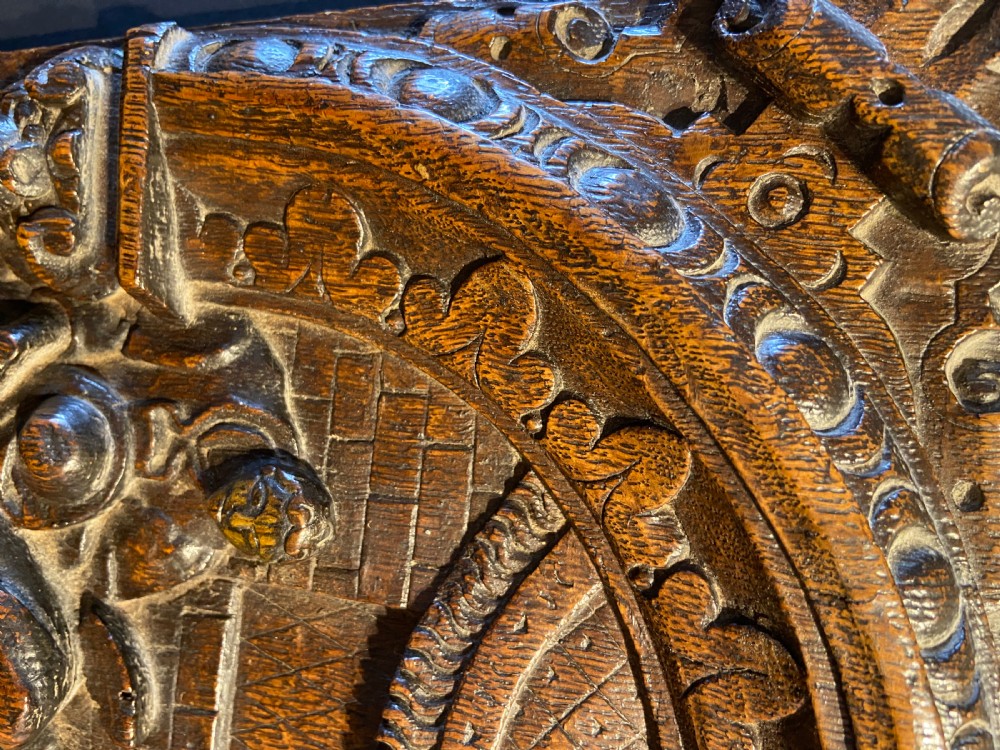 A 16th-century dark oak carved wood panel featuring a high-relief biblical scene enclosed within an arched frame supported by carved side columns. View IX
