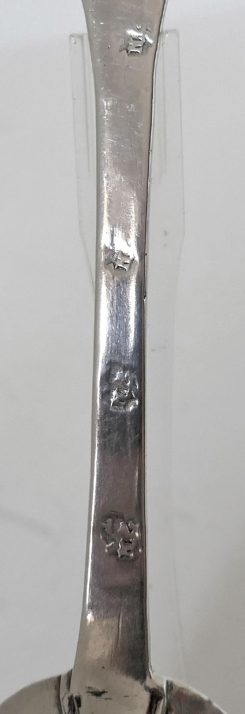 A 17th-century English sterling silver trefid spoon with a lobed terminal handle and an oval bowl displayed on a clear stand. View IV