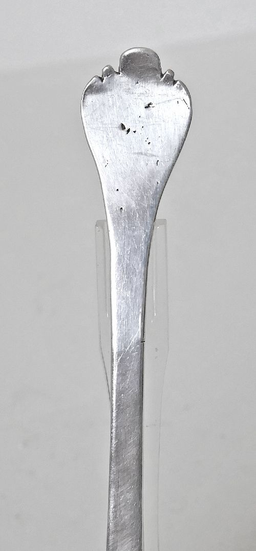 A 17th-century English sterling silver trefid spoon with a lobed terminal handle and an oval bowl displayed on a clear stand. View VII