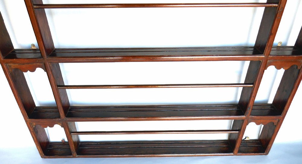 An 18th-century dark pine delft rack with a pierced fretwork frieze, a moulded cornice, three central plate shelves with retention bars, and open side alcoves. View IV