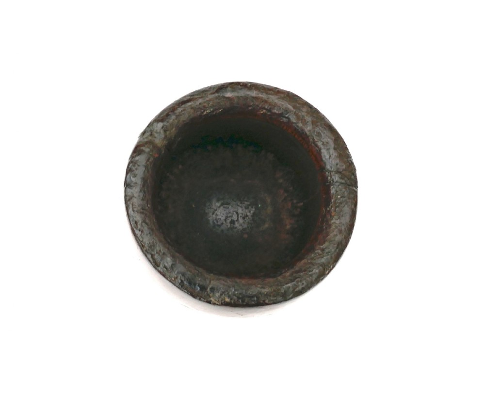 A turned dark fruitwood pestle resting inside a matching cylindrical wooden mortar with decorative incised lines. View VI