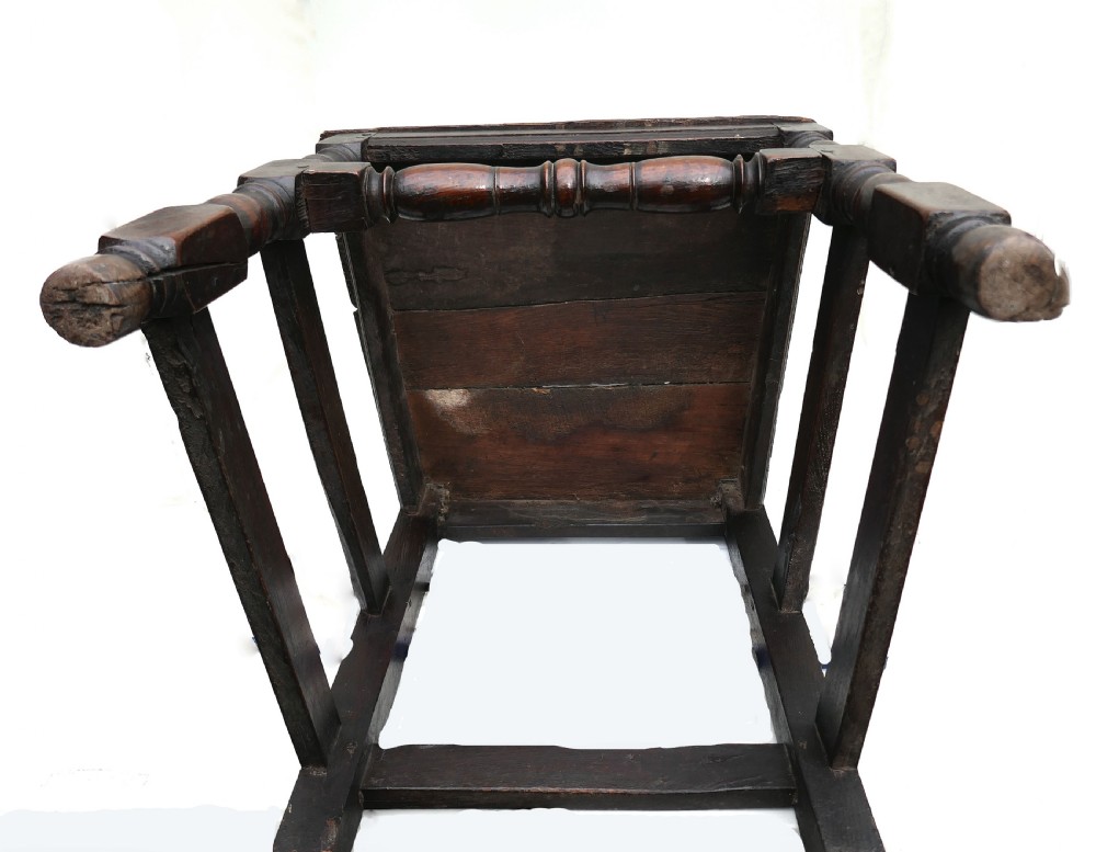 A late 17th-century dark oak side chair featuring a carved cresting rail, a pierced central splat back, turned legs, and a tapestry seat cushion with tassel fringe. View V