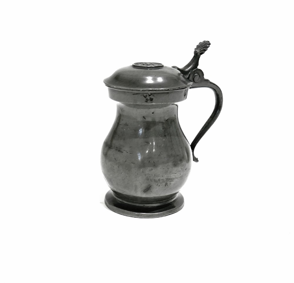A 19th-century Scottish pewter half-pint lidded measure featuring a bulbous body, curved handle, thumbpiece, and stepped foot.