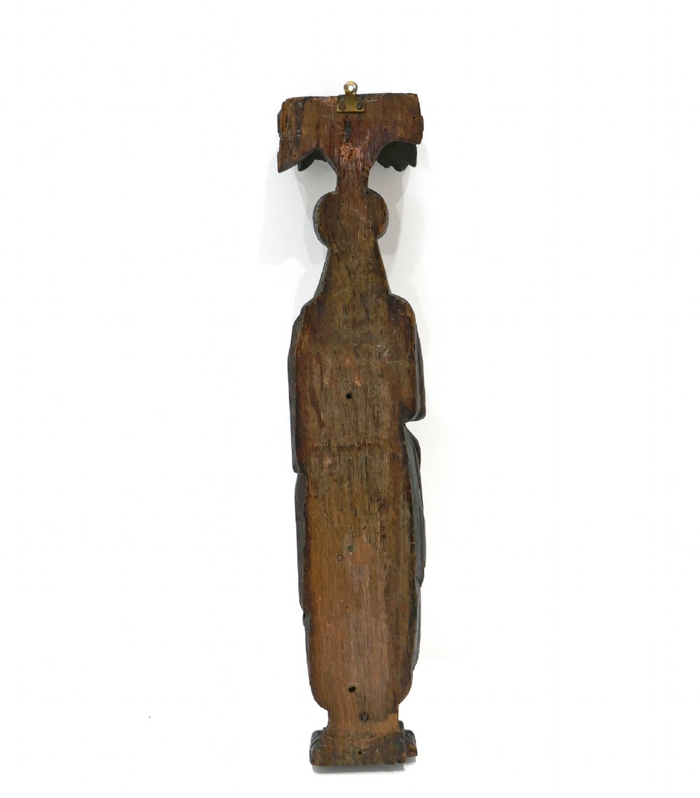 A dark seventeenth-century carved oak caryatid figure depicting a woman with crossed arms on a geometric strapwork base. View V