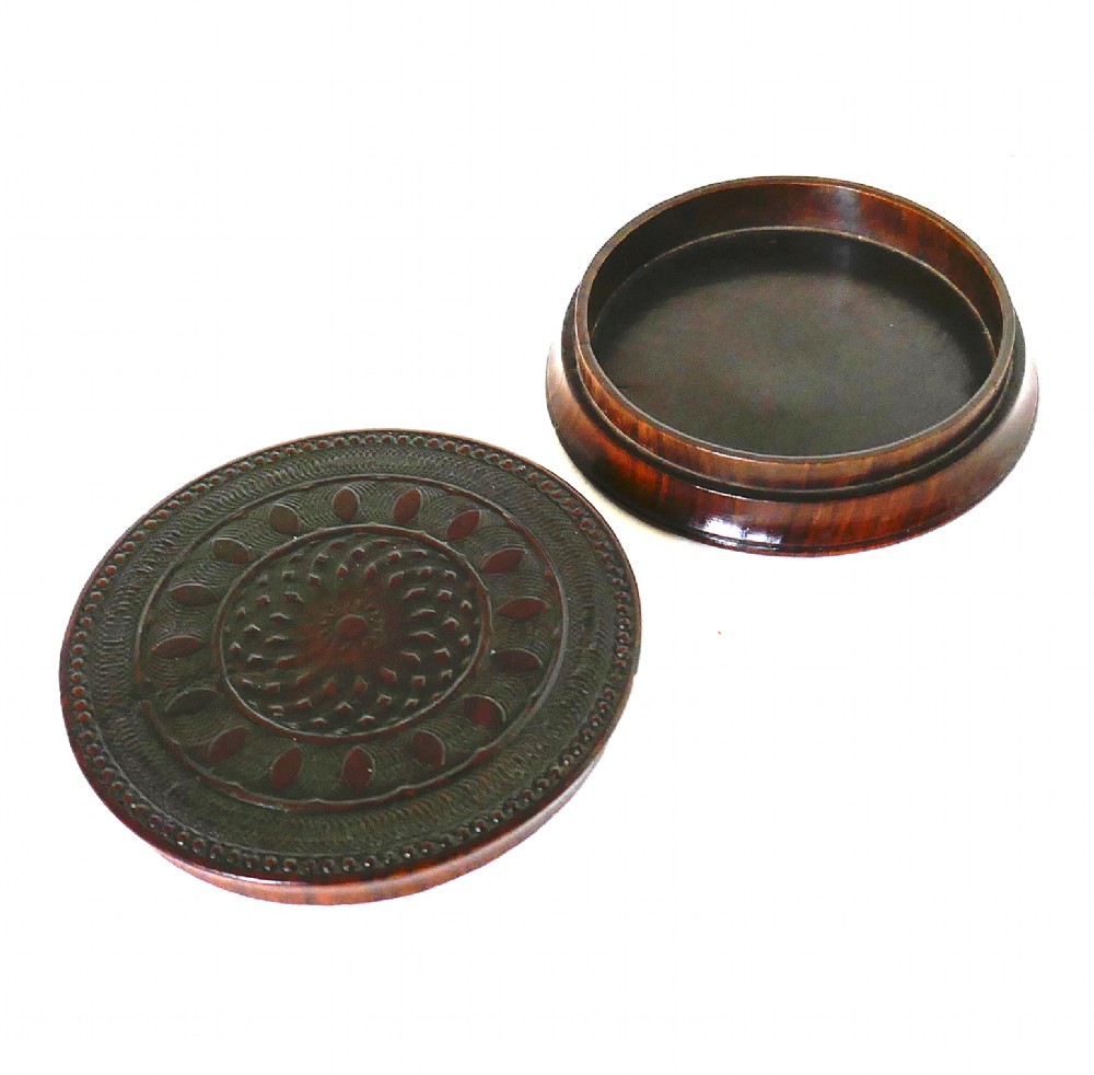 A circular early 19th-century dark laburnum wood snuff box featuring engine-turned geometric pattern carving on the lid. View III