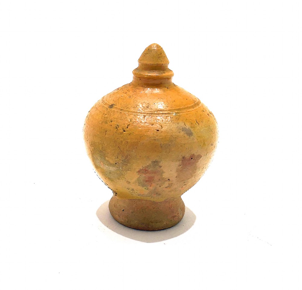 A nineteenth-century yellow glazed earthenware money box featuring a bulbous body, pointed finial, and coin slot near the top. View II