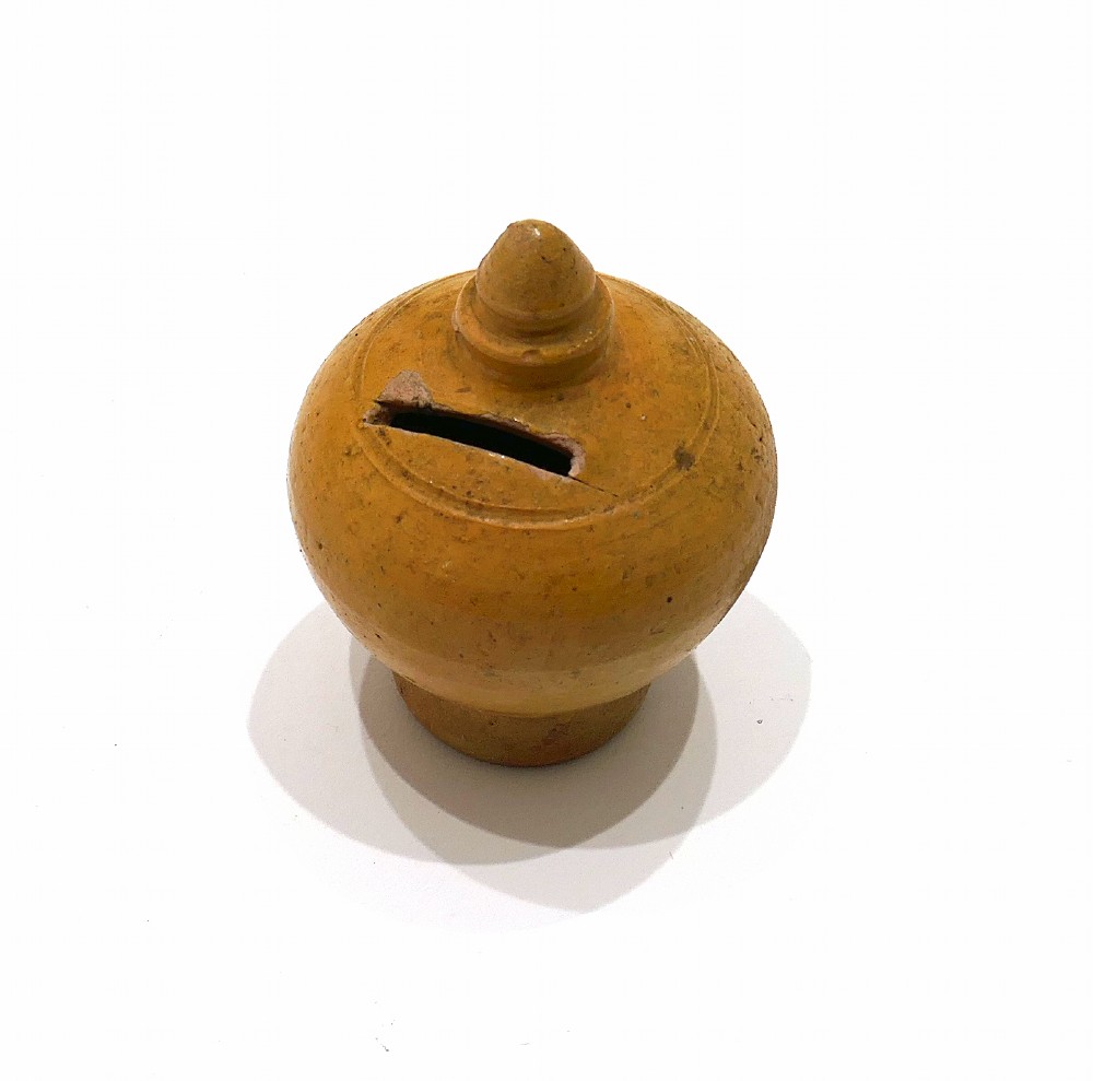 A nineteenth-century yellow glazed earthenware money box featuring a bulbous body, pointed finial, and coin slot near the top. View III