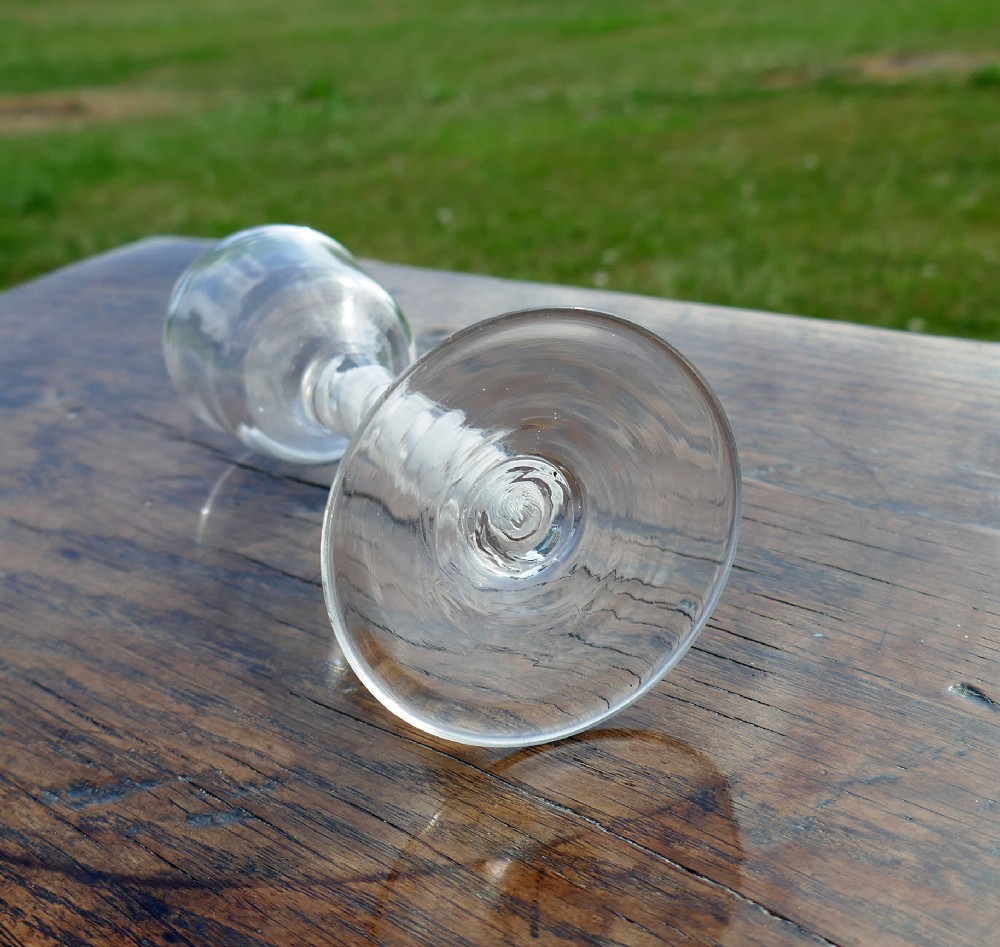 An eighteenth-century clear lead glass wine glass featuring an ogee bowl, an opaque white twist stem, and a conical foot. View II