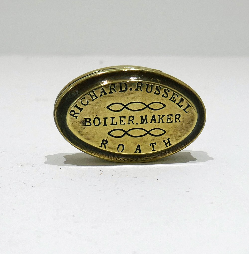 An oval antique brass snuff box with engraved lettering reading Richard Russell Boiler Maker Roath.
