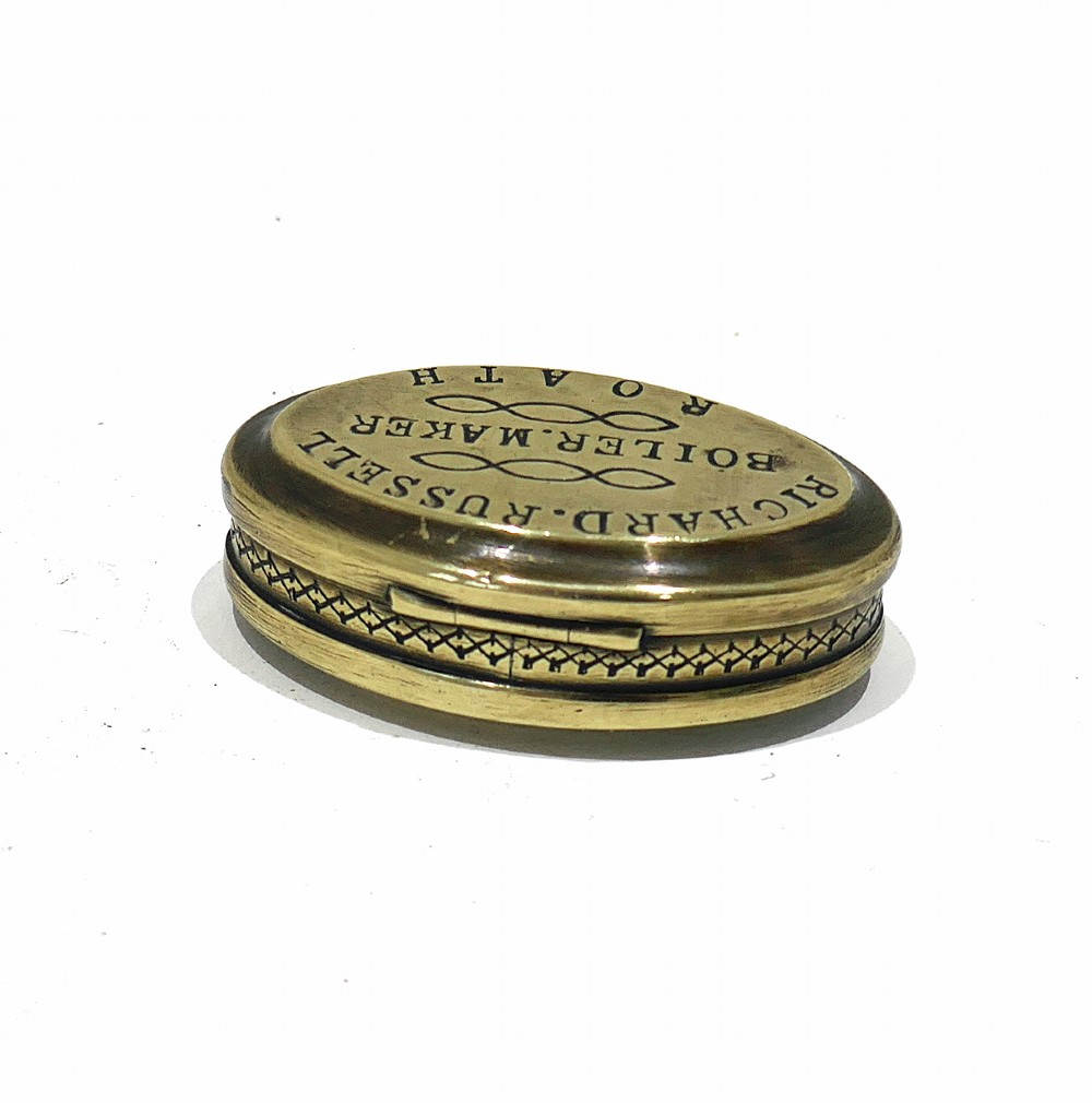 An oval antique brass snuff box with engraved lettering reading Richard Russell Boiler Maker Roath. View V