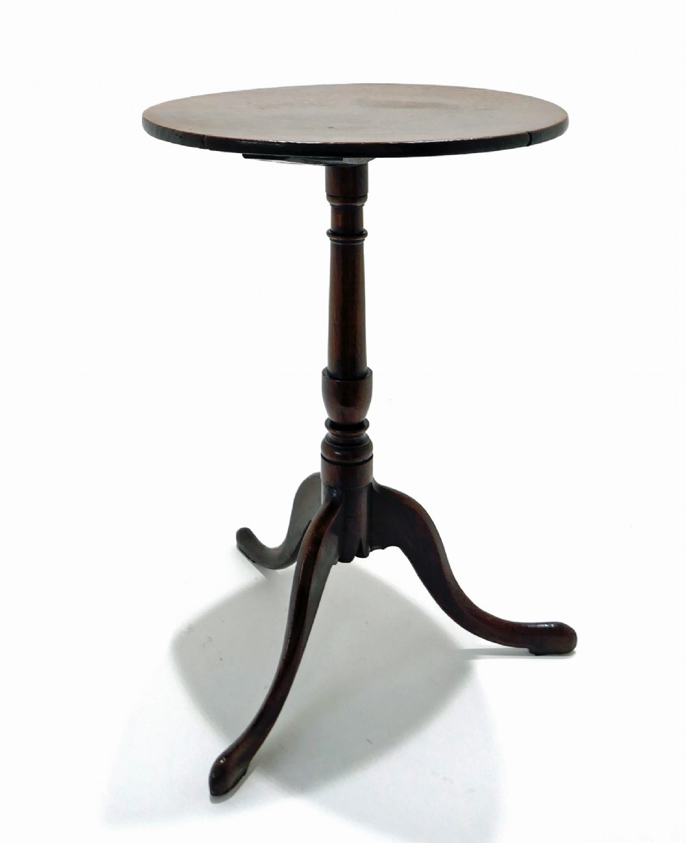 An 18th-century dark oak tripod table featuring a circular top, a slender turned central column stem, and three curved splayed legs.