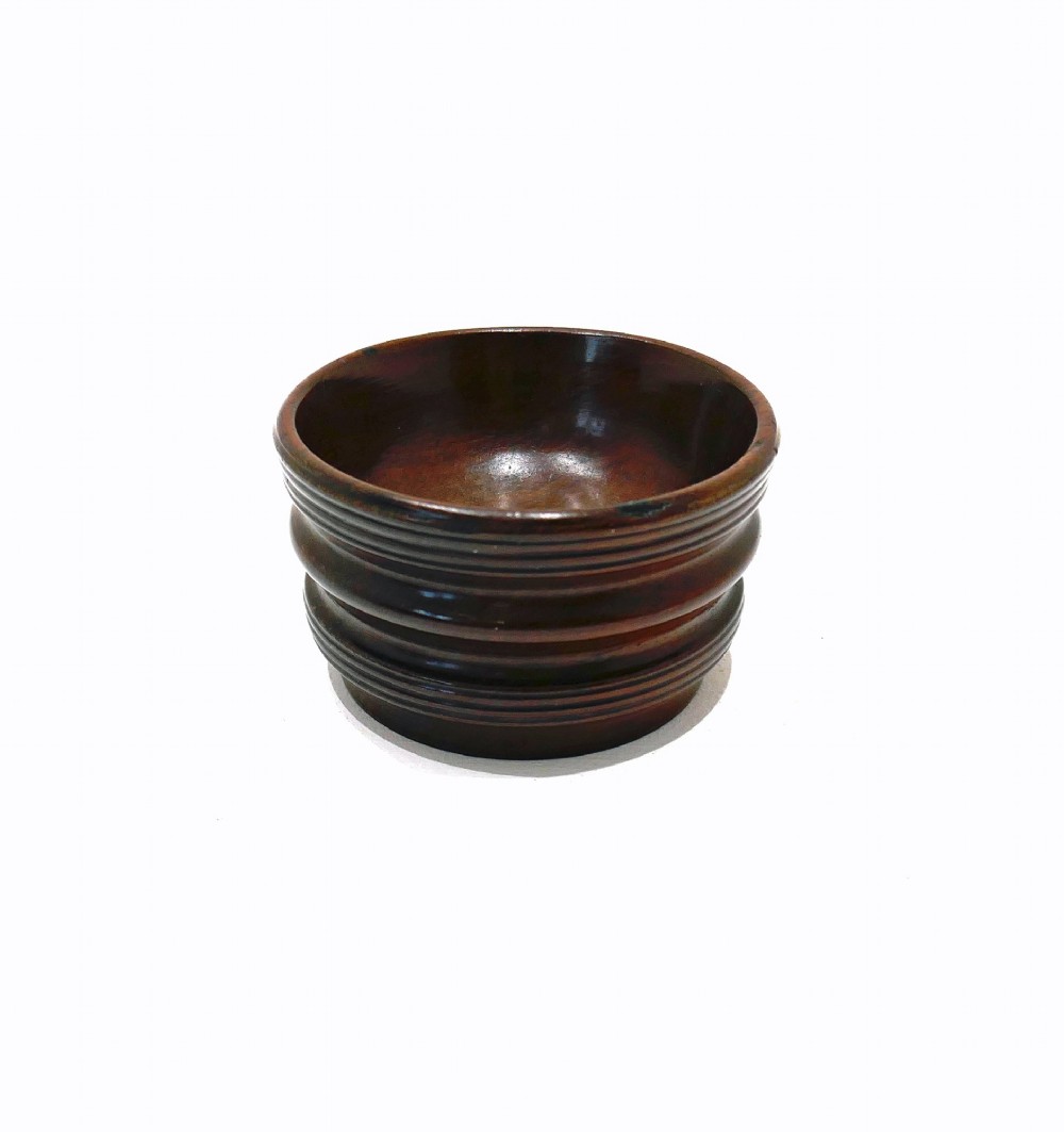 An antique late 18th-century turned laburnum wood open salt cellar featuring a ribbed exterior and a rich dark brown polished finish.