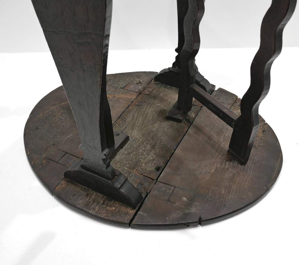 A seventeenth-century English dark oak gateleg table featuring a rounded drop-leaf top supported by shaped gates and trestle feet. View IV