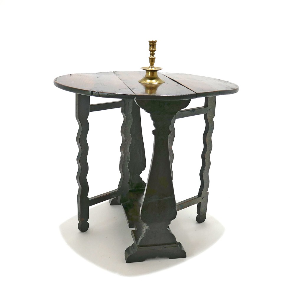 A seventeenth-century English dark oak gateleg table featuring a rounded drop-leaf top supported by shaped gates and trestle feet. View VI