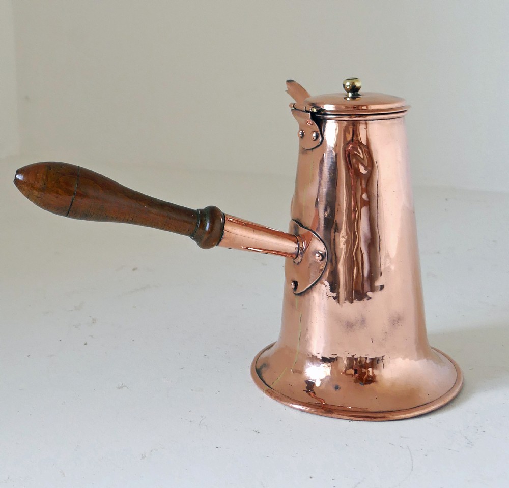 A Georgian copper coffee pot featuring a tapered body, flared base, swan-neck spout, hinged lid with brass finial, and a turned wooden side handle. View II