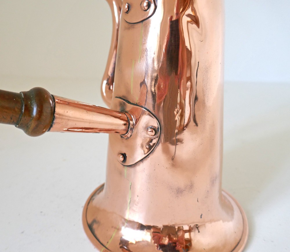 A Georgian copper coffee pot featuring a tapered body, flared base, swan-neck spout, hinged lid with brass finial, and a turned wooden side handle. View IV