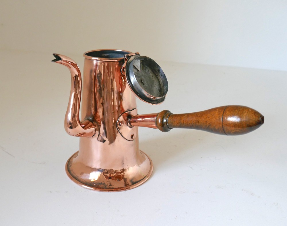 A Georgian copper coffee pot featuring a tapered body, flared base, swan-neck spout, hinged lid with brass finial, and a turned wooden side handle. View VI