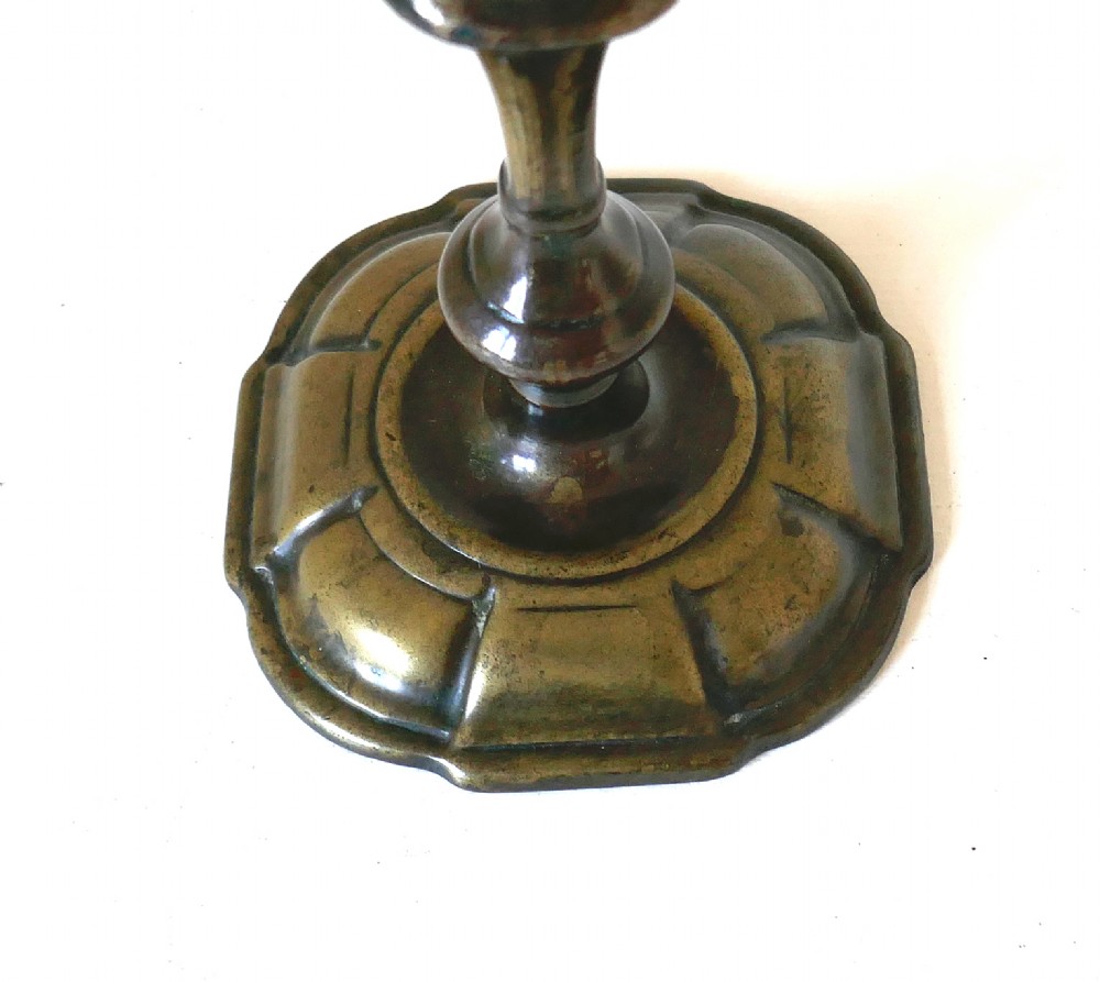 An eighteenth-century cast brass candlestick featuring a baluster stem and a scalloped base with dark surface patina. View III