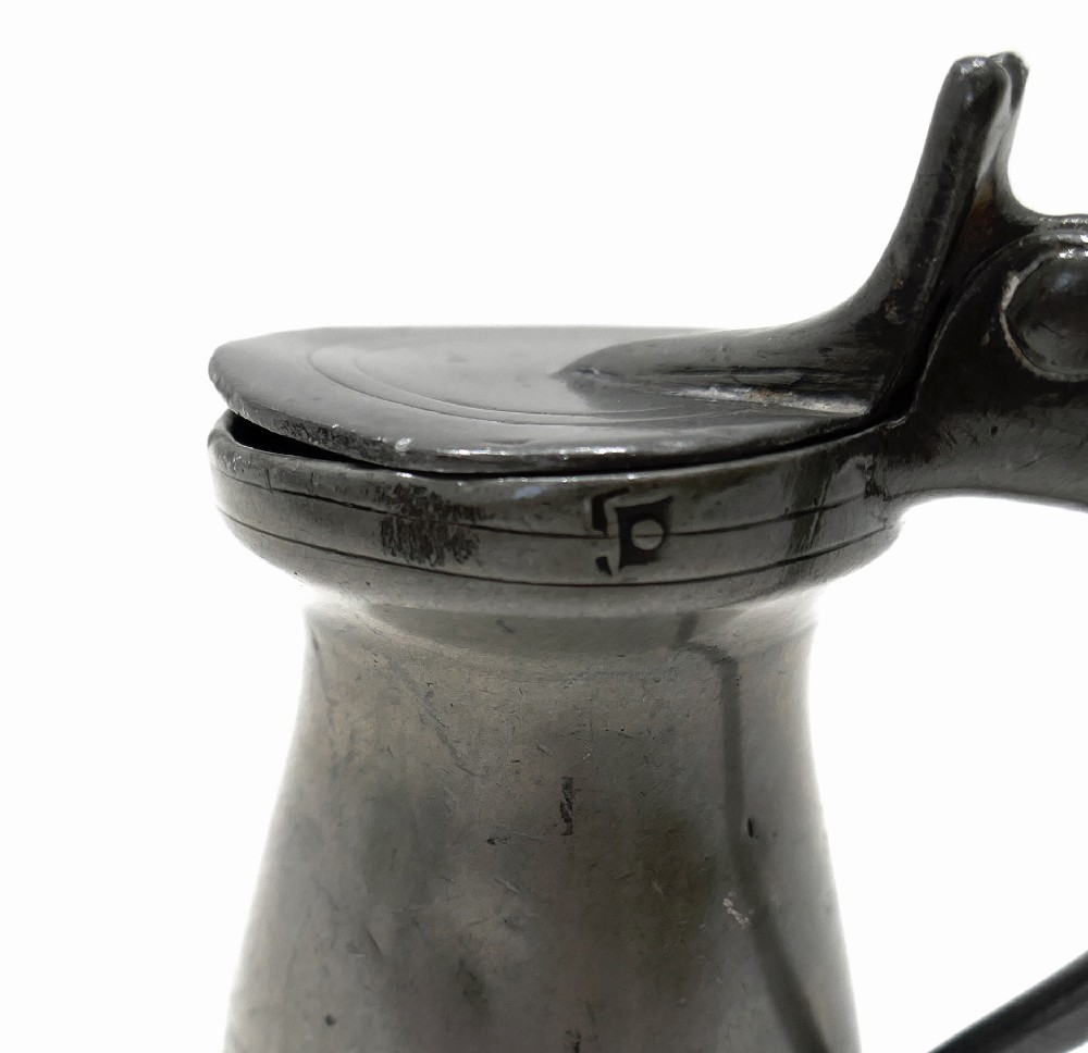 An 18th-century English pewter spirit measure featuring a flat hinged lid, curved handle, and incised horizontal lines around a baluster body. View VII