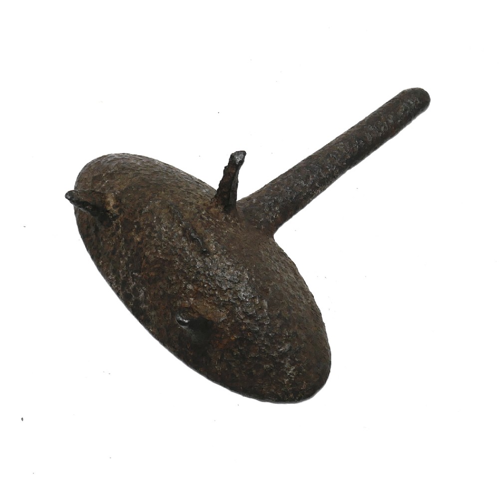 A 17th-century cast iron hearth grisset featuring a shallow boat-shaped vessel with three short tripod feet and a straight handle against a white backdrop. View V