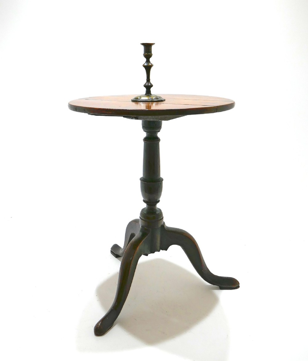 An 18th-century English Georgian tripod table featuring a circular tilt top supported by a turned baluster stem and three curved cabriole legs.