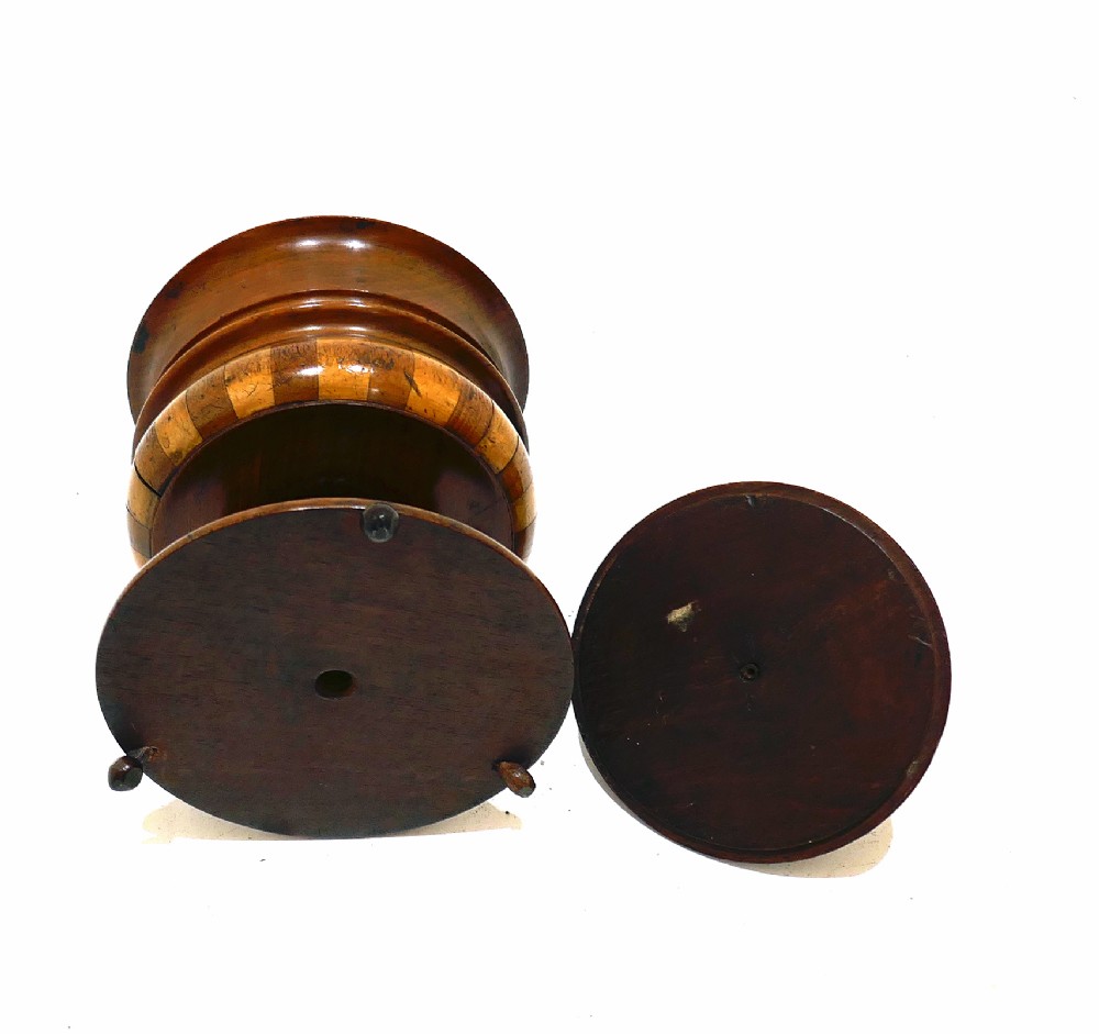 A turned antique wooden lidded tobacco jar with staved bands of light and dark timber, set on a pedestal base with small ball feet. View III