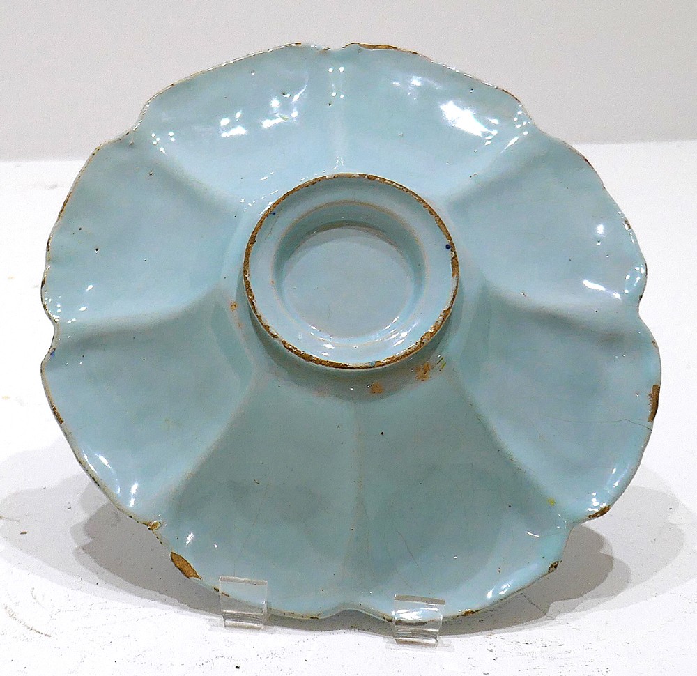 An antique 17th-century English tin-glazed earthenware lobed dish featuring hand-painted cobalt blue floral panels and a central landscape scene. View III