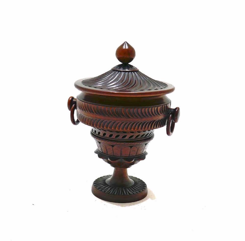 An early 19th-century turned fruitwood lidded pomander cup featuring a finial top, spiralled fluting, carved ring handles, and a pedestal base.