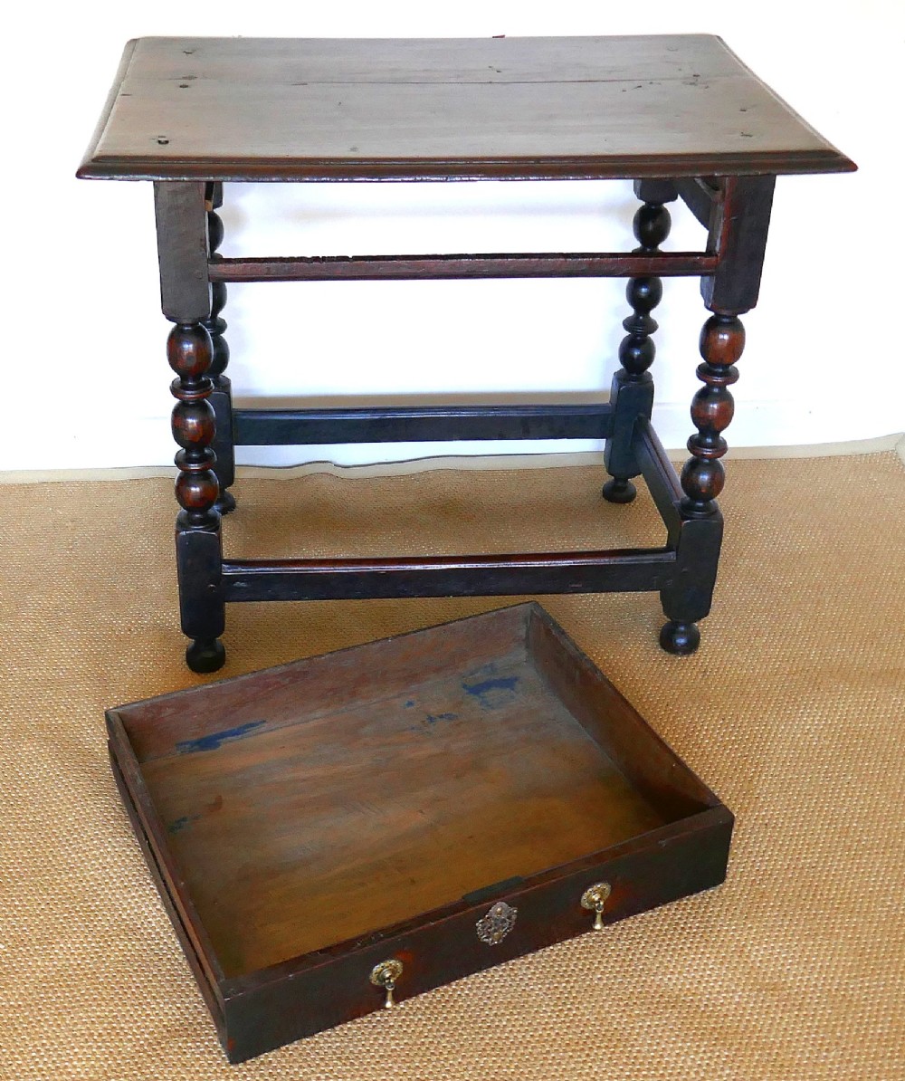A 17th-century English oak side table featuring a single drawer with brass drop handles, turned ball legs, and a perimeter stretcher base. View III