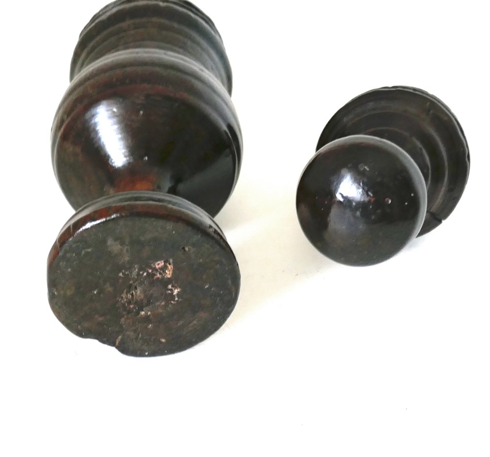 A turned dark sycamore wood two-part spice grinder featuring a baluster-shaped body, ribbed tiering, and a round finial top. View IV