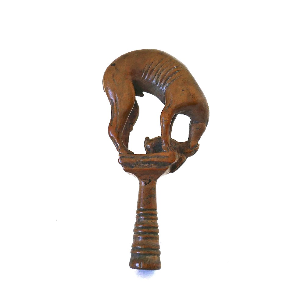 An eighteenth-century boxwood pipe tamper hand-carved in the shape of a greyhound atop a turned pedestal.