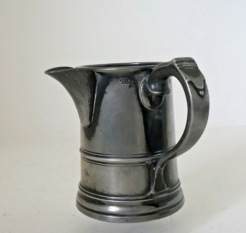 An antique 19th-century pewter ale jug featuring cursive inscription engraving, a pinched pour spout, and a moulded flared base. View II