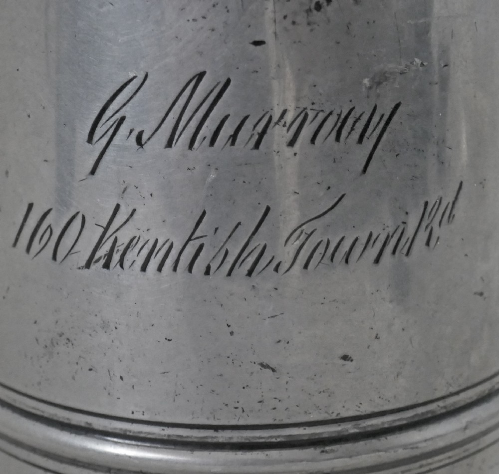An antique 19th-century pewter ale jug featuring cursive inscription engraving, a pinched pour spout, and a moulded flared base. View IV