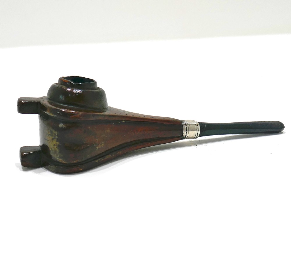 A nineteenth-century carved fruitwood tobacco pipe shaped like miniature fireplace bellows with an ebonised stem and metal ferrule band.