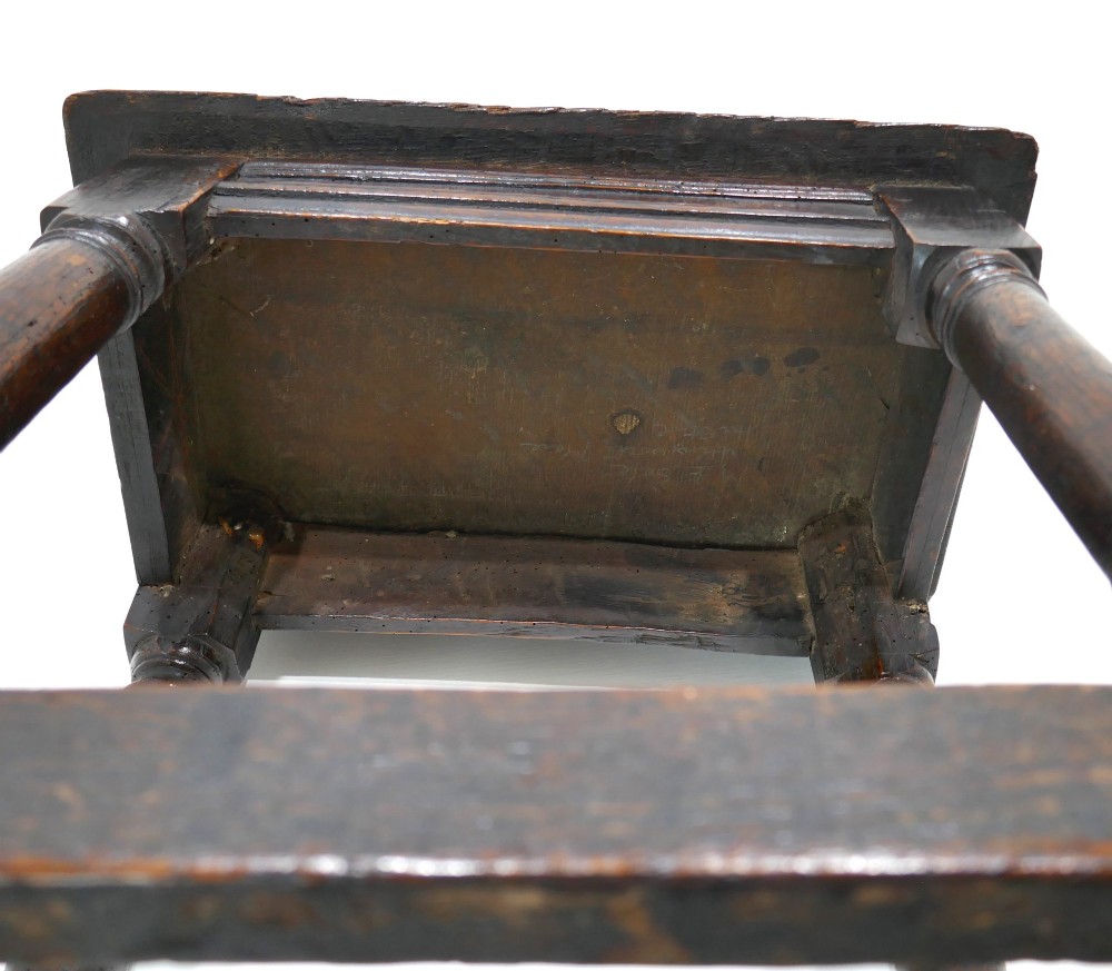 A 17th-century Commonwealth joined oak stool featuring turned legs, pegged mortise joints, lower stretchers, and a moulded rectangular seat. View IV